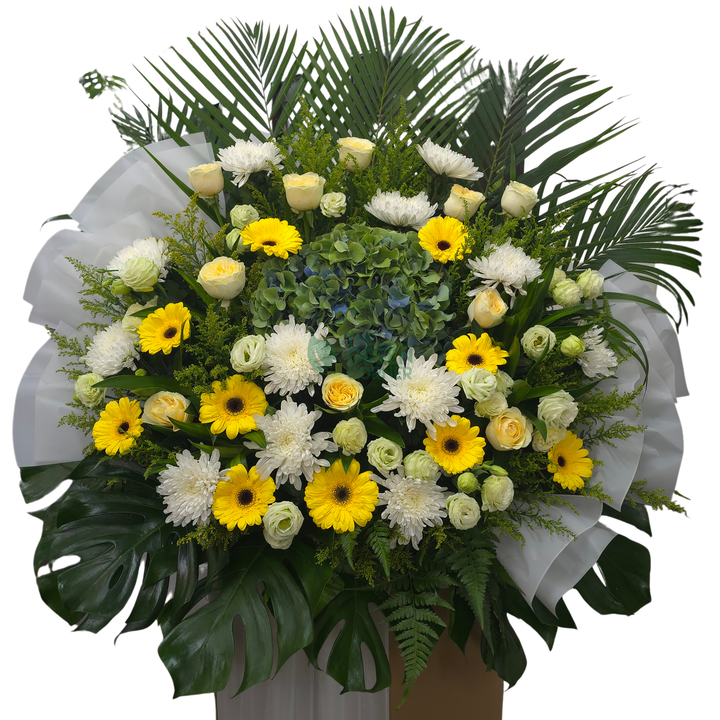Close-up of the Aura de Fleurs condolence wreath showing white chrysanthemums, yellow gerbera and green hydrangea