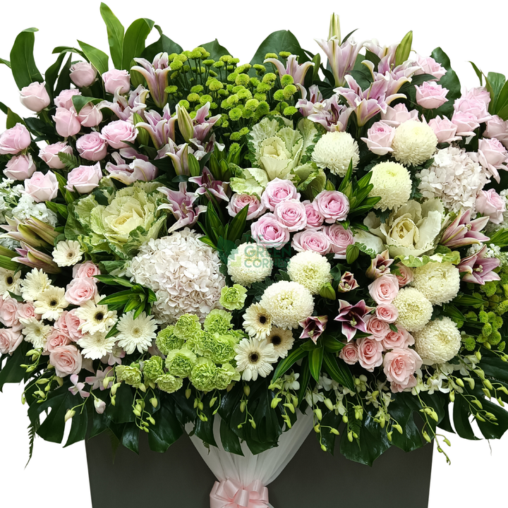 Close-up of the Timeless Garland condolence wreath showing pink roses, white chrysanthemums, lilies and green hydrangea
